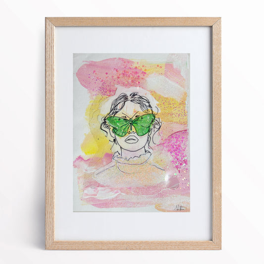 6x8 inch painting of a girl wearing moth-shaped glasses by Natalie Russo, featuring a vibrant acrylic background in soft pinks and yellows with glitter accents. The painting is framed and displayed